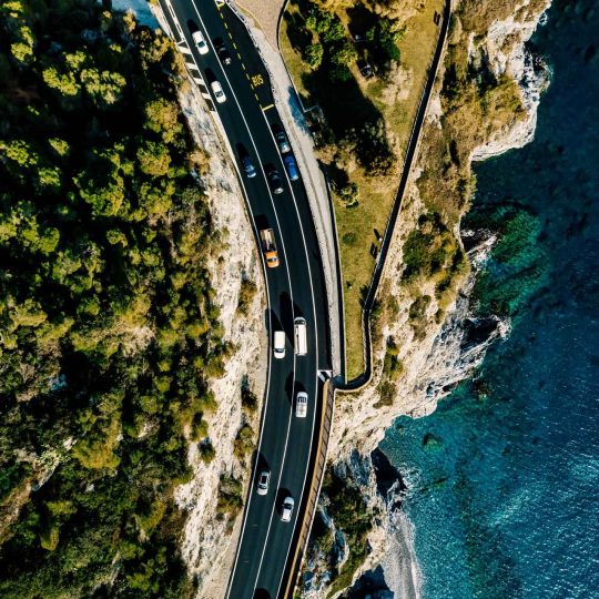 aerial-view-of-road-going-along-the-mountain-and-o-YM4JAH8.jpg