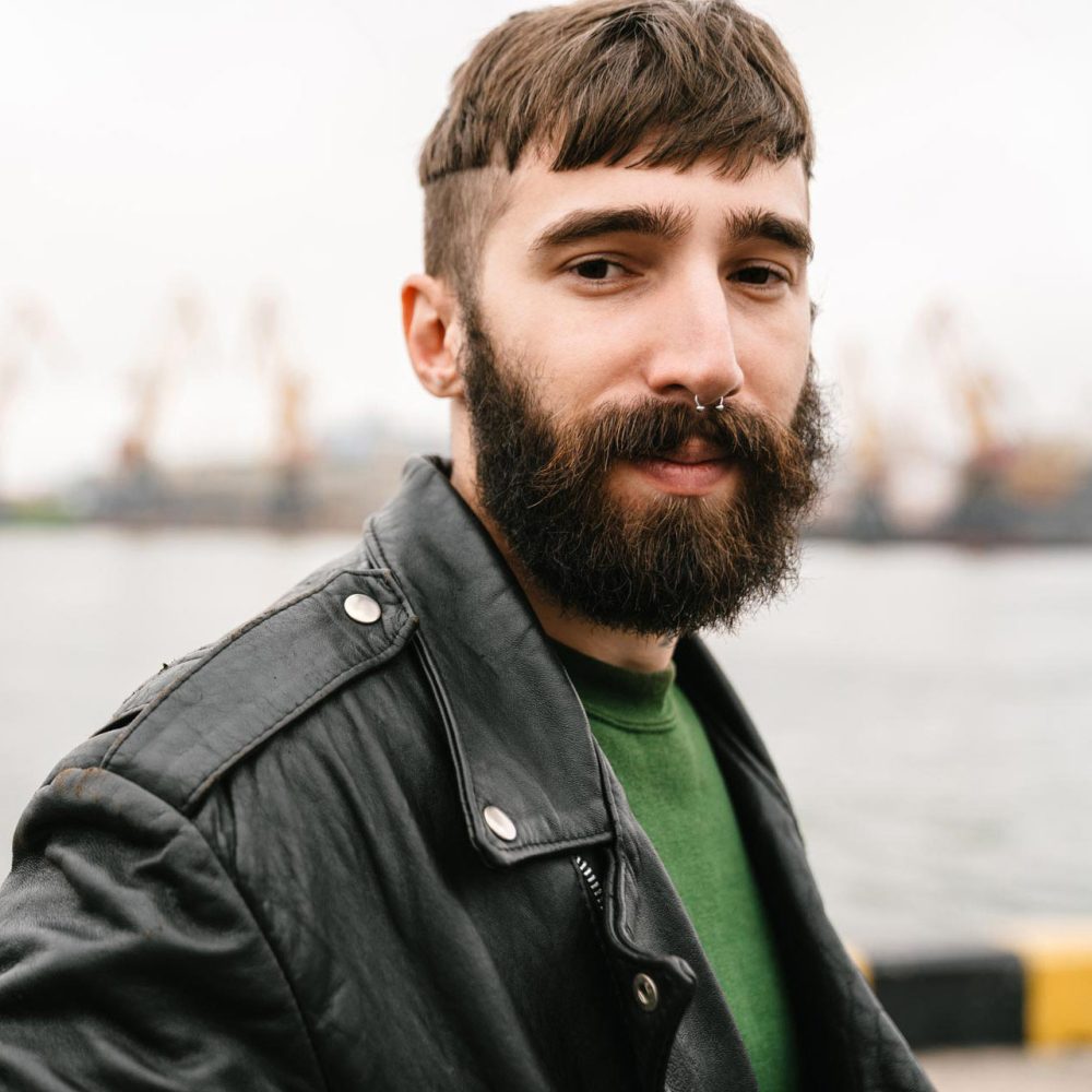 photo-closeup-of-bearded-young-man-looking-at-came-UDSWHUP.jpg