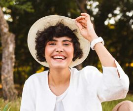 pretty-laughing-girl-sitting-in-hat-and-white-shir-9LAQS5W.jpg